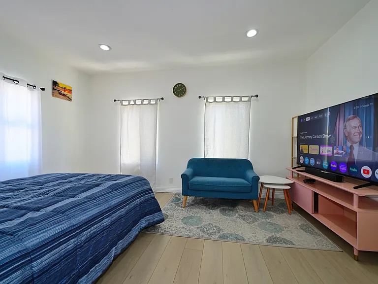 Super spacious bedroom furnished with TV, queen bed and mattress, mini split AC, Loveseat and Coffee table - with views of PCC