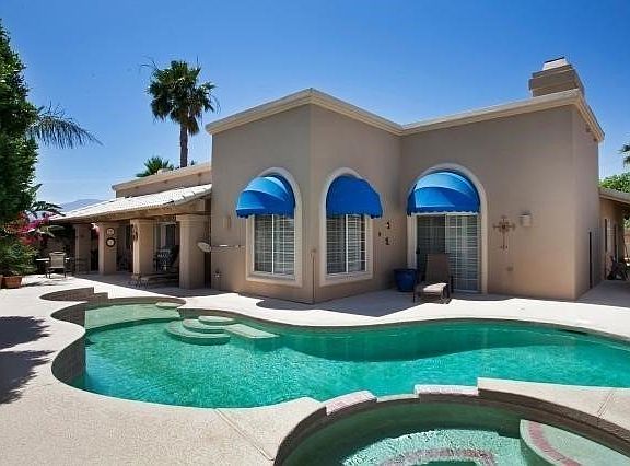Rear view of the home with swimming pool, waterfall jacuzzi and covered patio