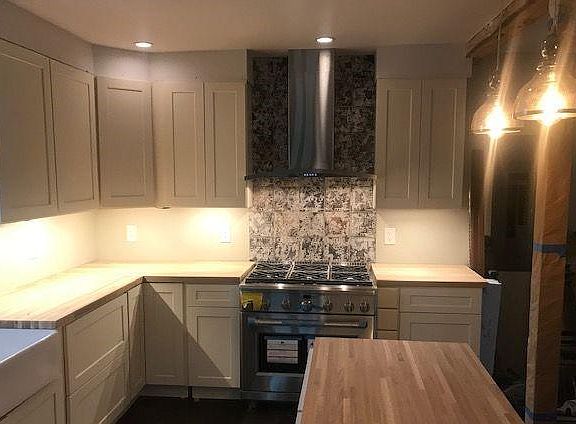36" GE Cafe range with over-the-range hood that vents to outside. Also, pendant lights over the island.