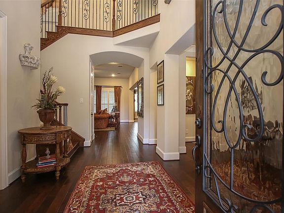 Step past the custom iron and glass door into this amazing entry adorned with hardwood flooring that flows throughout most of the bottom story of this home!