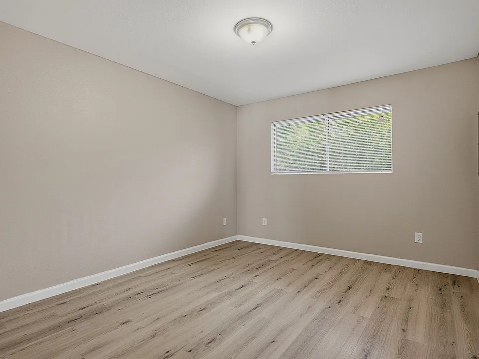 Bedroom with wood-style flooring and a large window at The Crawford at Denison.
