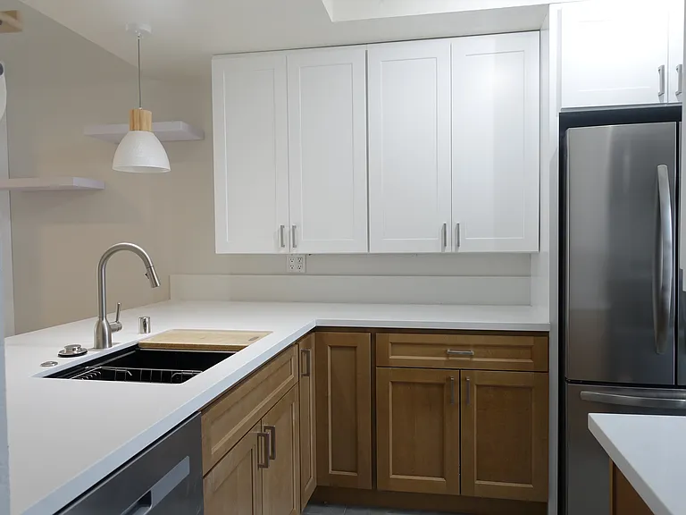 Kitchen: New white and oak cabinets with quartz countertop and stainless steel appliances.White oak lighting. Grey tile flooring.