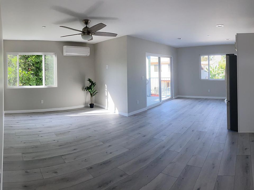 Panoramic shot from front door - LR on left, balcony through sliding doors in the middle, galley kitchen on right.