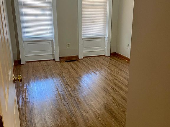 Spacious front bedroom with large windows.