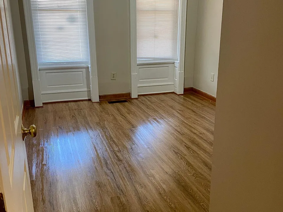 Spacious front bedroom with large windows.