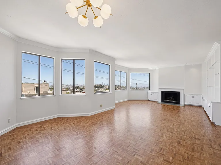 Open dining / living area with expansive views, decorative fireplace, and abundant built-in cabinetry & shelving.