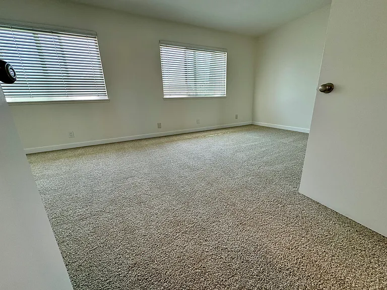 Spacious master bedroom (2 bedrooms converted to 1) with new wall to wall carpet, mirrored wardrobe doors and paint!