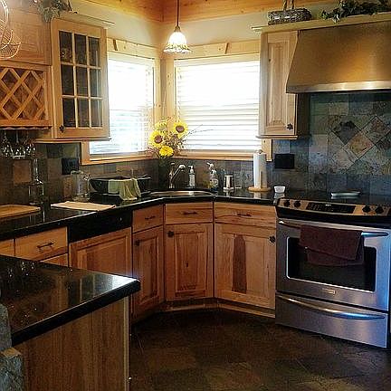Kitchen has glass cabinets, backsplash