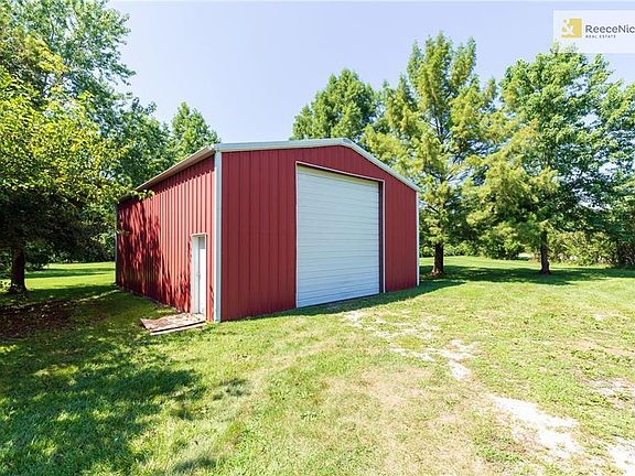 40x30 Outbuilding/Garage features concrete floor, 14 foot garage door, side door and enough space for 4+ cars!