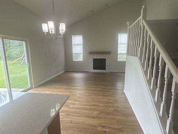 open concept kitchen and living room with vaulted ceilings and fireplace