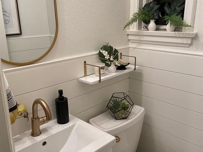 White powder room with shiplap and gold accents