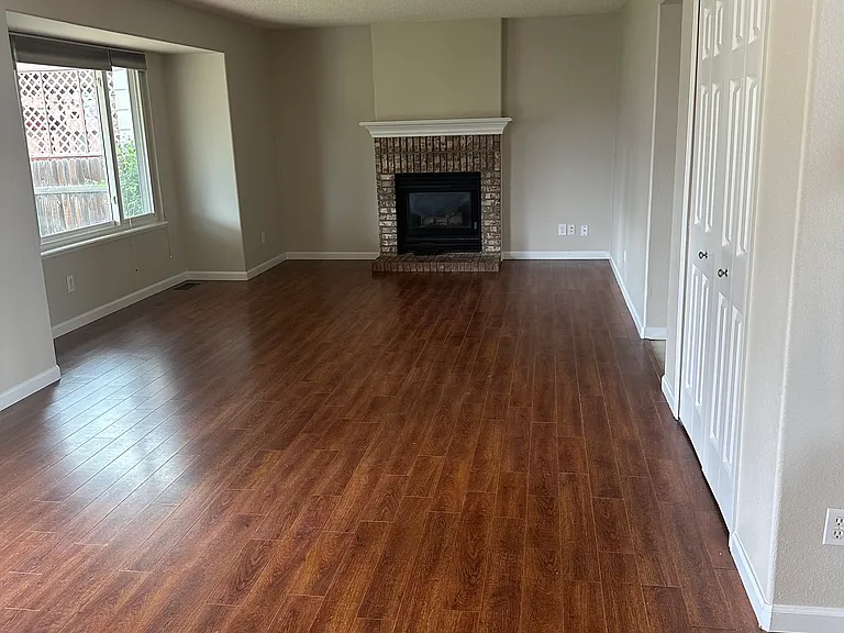 View of family room with large picture window and gas fireplace.