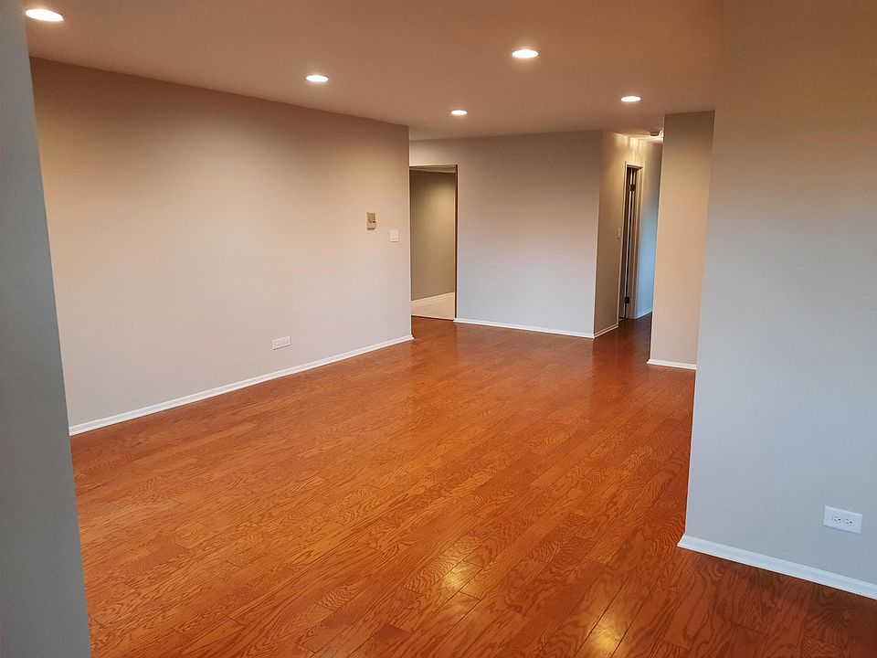 Living room, looking west towards the entry hallway and hallway to bedrooms. Hardwood laminate flooring.