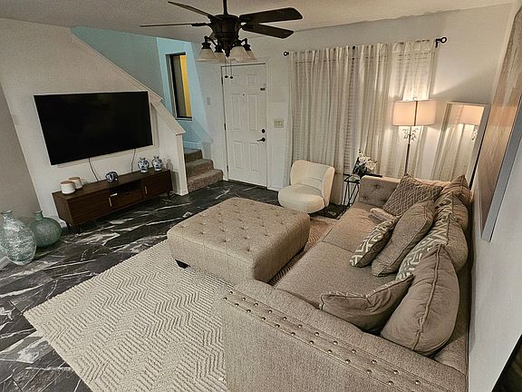 The first floor features an open-concept design, with the living room flowing seamlessly into the kitchen. A TV mount is installed and set up, ready for use.