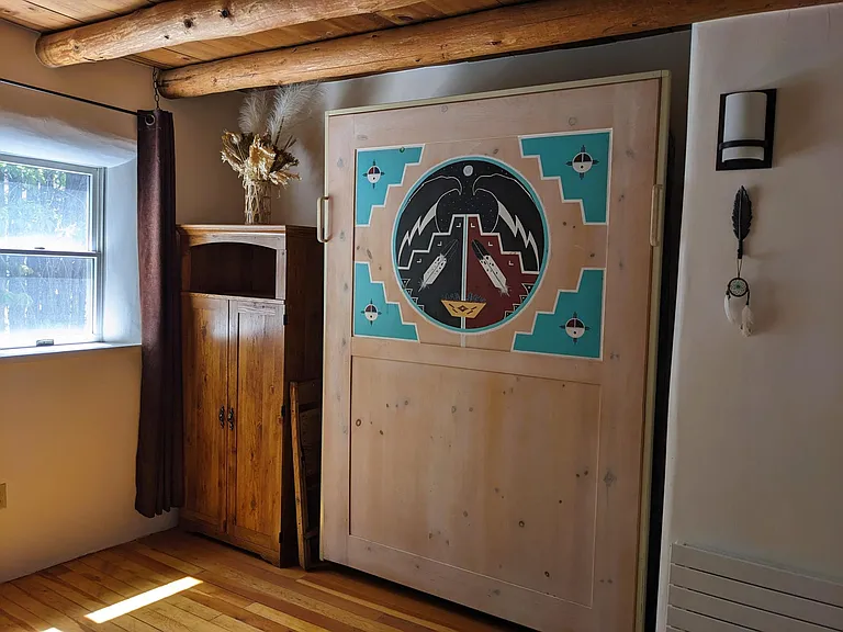 Guest bedroom with original Native American painted murphy bed and workstation armoire