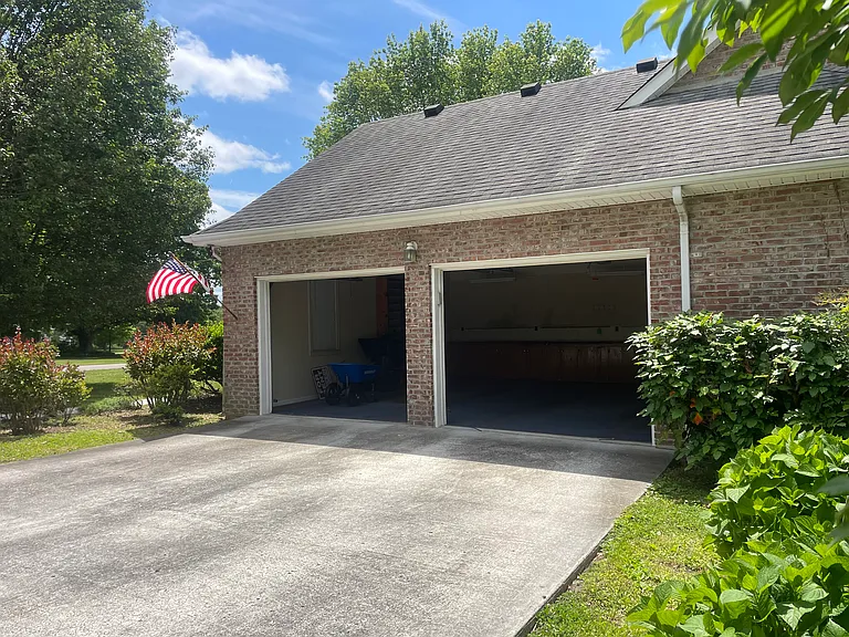Garage with storage shelves, cabinets and additional storage room located off the garage