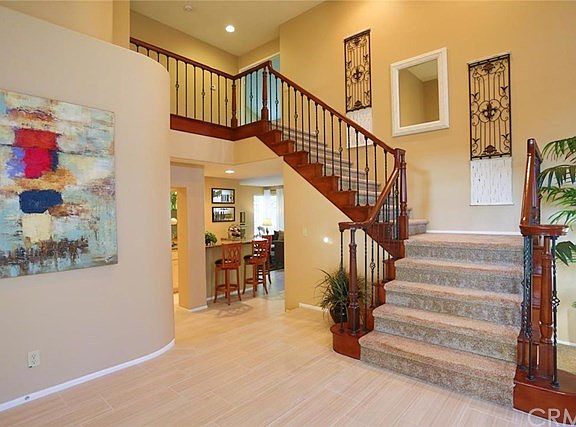 Entry showing custom stair railing, two story entry, new ceramic tile flooring.