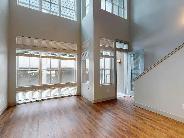 Apartment living room with wood-style flooring and balcony or patio.