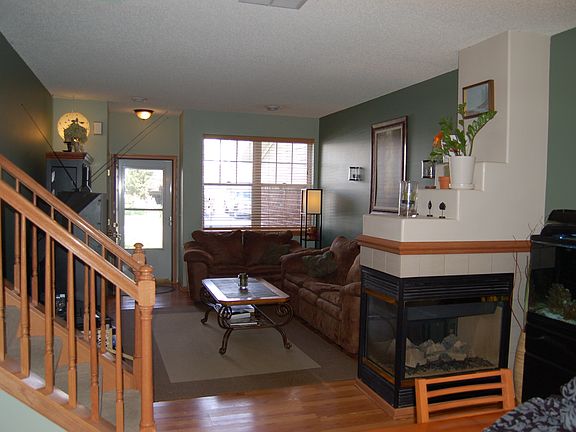 Living room includes wood laminate floors and 3-sided firepl