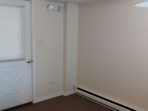 Front door closed in kitchen. Directly across from table.
