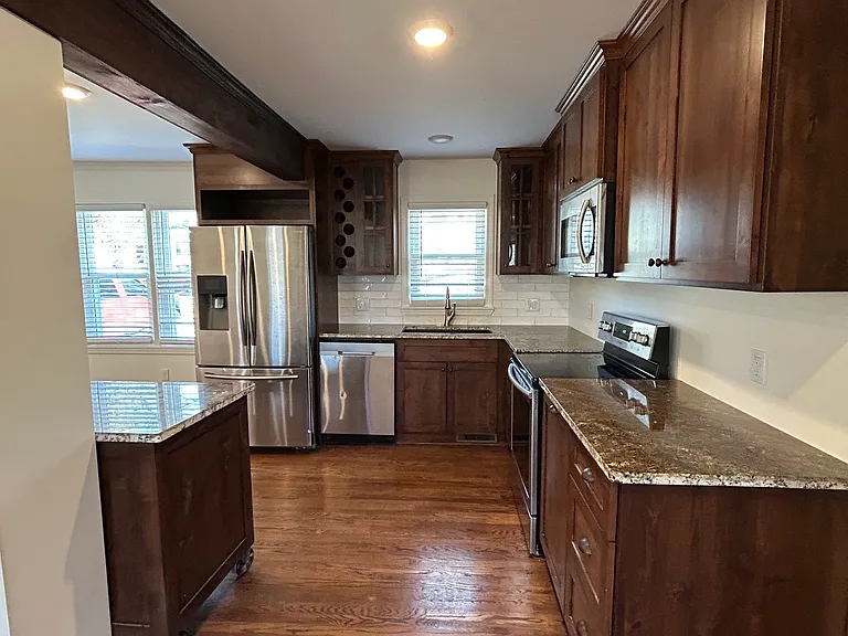 Newly renovated kitchen with stainless steel appliances and marble countertops.
