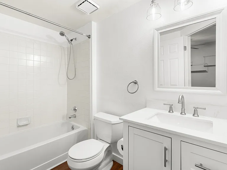 Second bathroom features an updated vanity with ample storage, a shower with removable handheld showerhead, and convenient access from the main living area for guests.