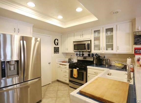 Kitchen showing updated lighting, stainless appliances and glass