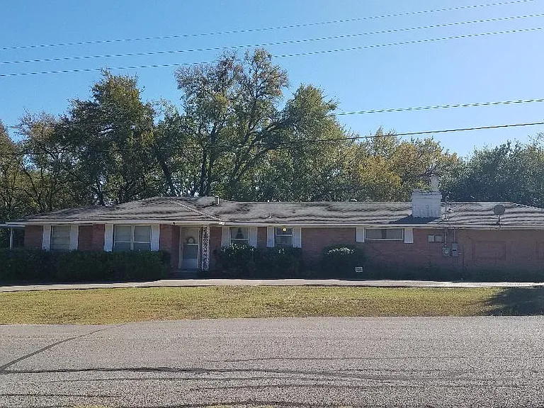 The is a picture of the front of the house. It has a circular driveway.