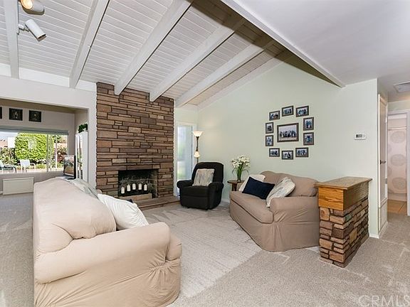 Patio & backyard view through the rear window, open beam ceiling, bedroom hallway to the right.