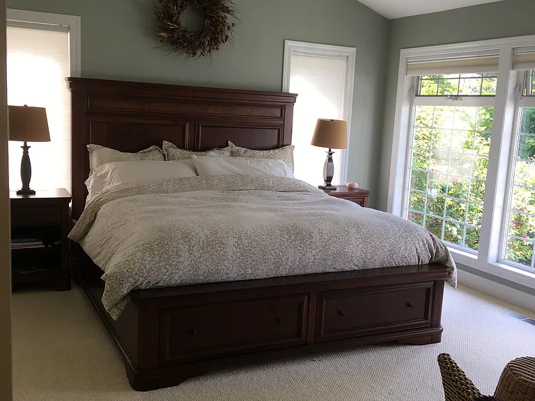 Primary Bedroom. Pull down white fabric honeycomb window blinds.