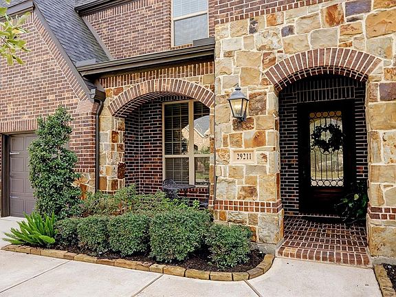 Sit out and enjoy watching the kids play on the cul de sac, or drink a cup of morning coffee , on this brick and stone covered front porch with paved brick floor, arched stone and brick details with an oversized glass and wrought iron front door.
