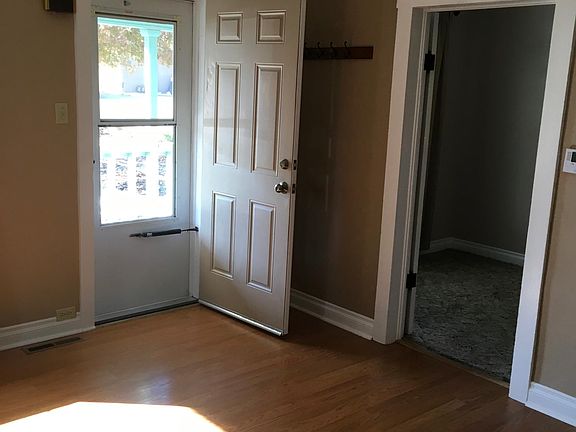 View from back of living room toward front door, 2nd bedroom through door.