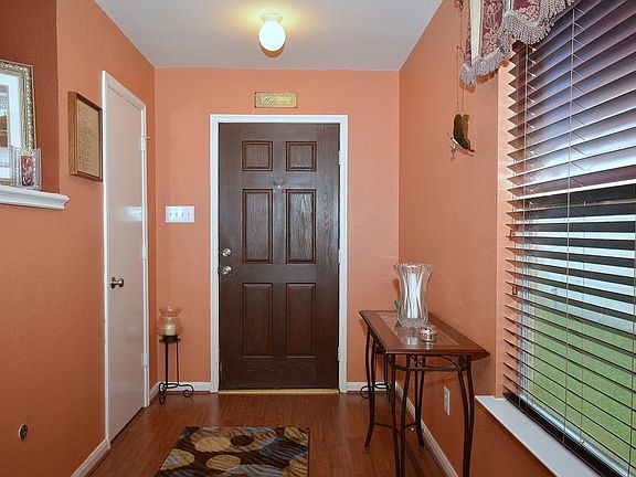 Entry way with laminate floors leads to open living area.