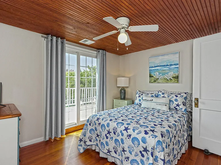 Bedroom with full size bed and hardwood floors.