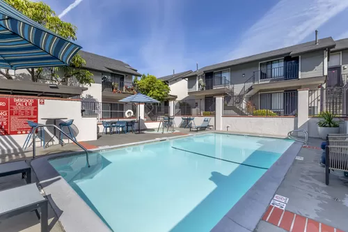 Dive into luxury living at Independence Plaza, where every day feels like a vacation with our refreshing swimming pool and stylish patio retreat adorned with cozy umbrellas. - Independence Plaza Apartment Homes