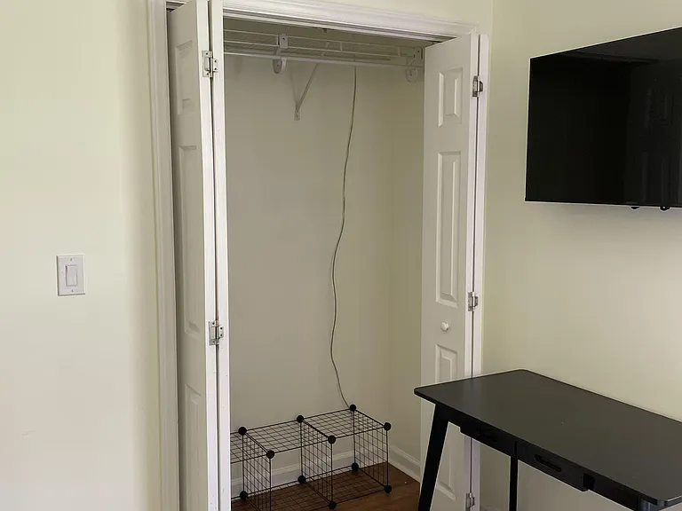 Bedroom with a reach-in closet featuring double doors and a top shelf/rod for convenient everyday storage.