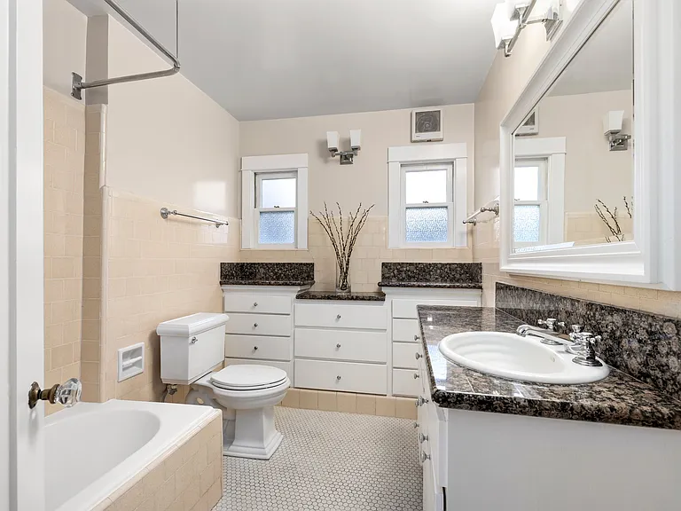 Bathroom with full tub/shower, storage, and character hardware