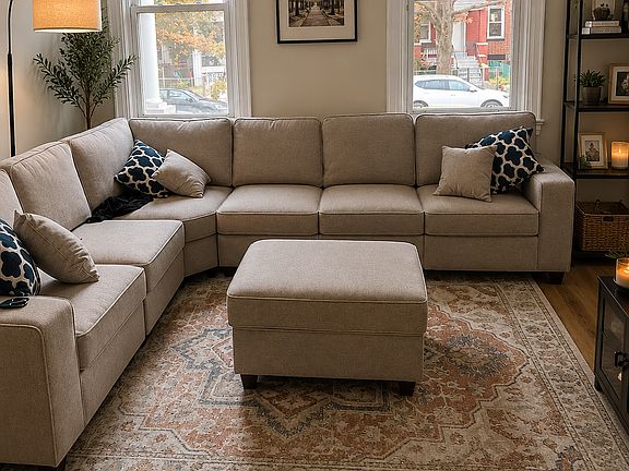 Front living room. The sofa, ottoman and rug are new from 2025 and can convey with the rental.