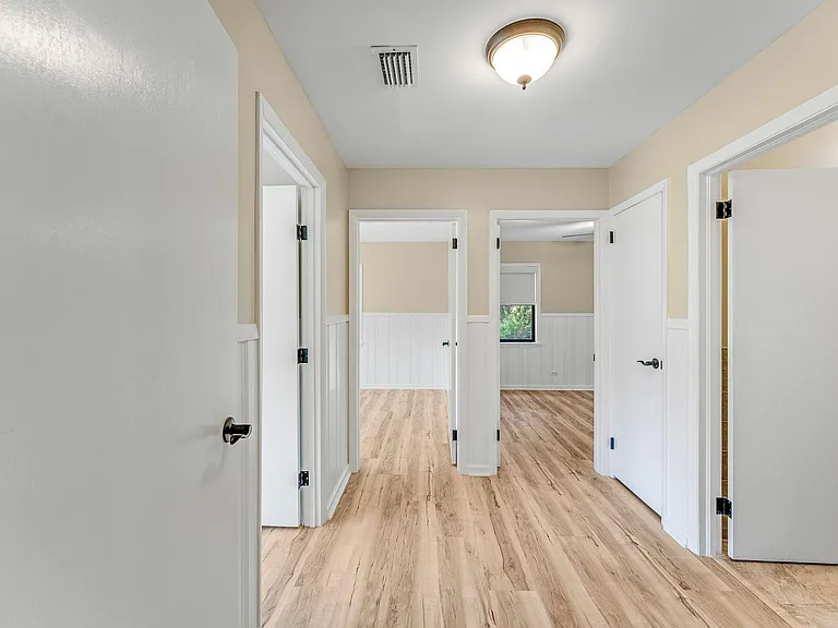 Hallway leading to bathroom and three bedrooms.