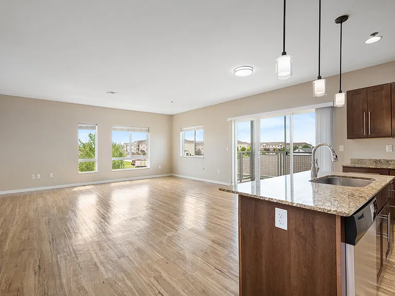 Bright open-plan living space with large windows, modern hardwood floors, and stylish kitchen island with granite countertops. Bright open-plan living space with large windows, modern hardwood floors, and stylish kitchen island with granite countertops.
