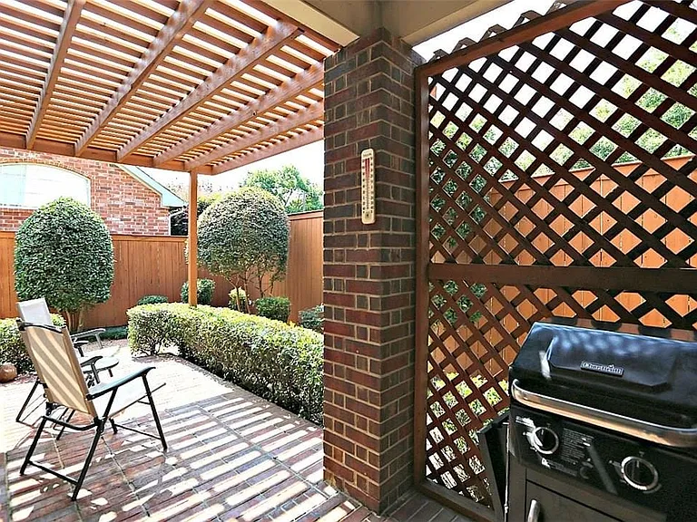 Brick patio featuring a wood pergola and lattice privacy screen