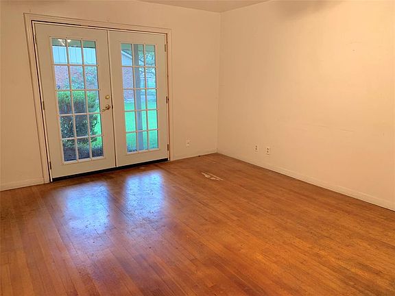 View of formal living room with French doors overlooking front yard.