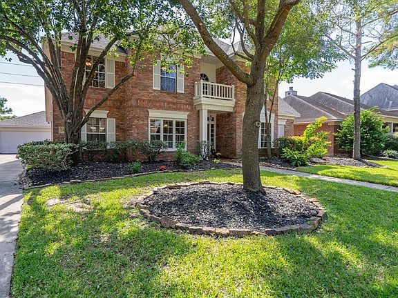 Brick exterior with classic shutters, balcony, mature trees and landscaping offers greats curb appeal!