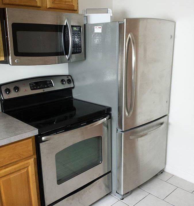 updated stainless appliances with icemaker and microwave. comfortable height GE fridge