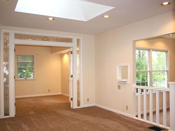 Large Dining room is a step up from the living room and features a large skylight and access to the den with french doors.