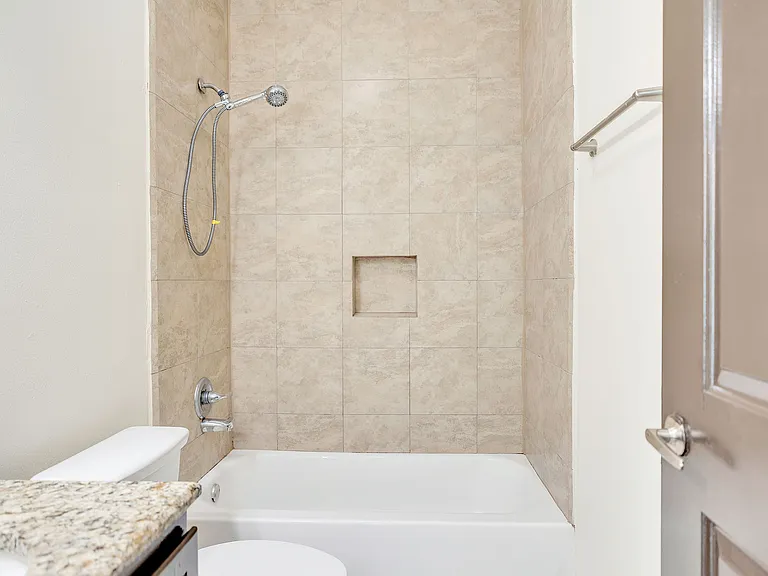 A well-appointed bathroom at La Joya Apartments, including a shower, toilet, and sink, highlighting contemporary style