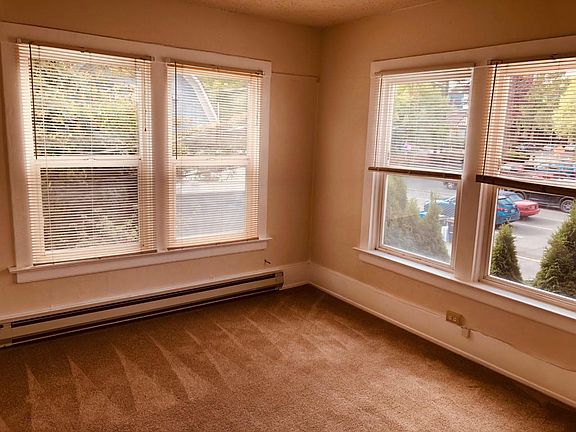 Bright corner living room with large windows and like-new carpet