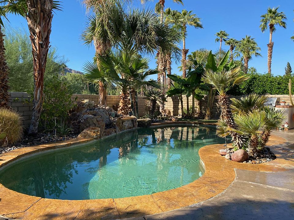 Lush private backyard with saltwater pool and waterfall.