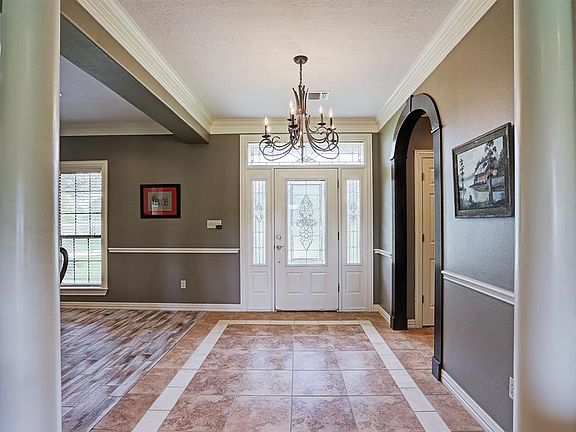 Beautiful tile entry with chandelier, notice the amazing wood work with the curved walkway.