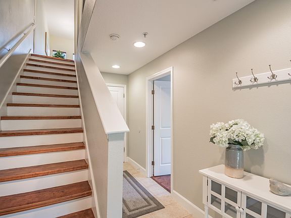 The first floor features a welcoming entryway, bedroom with attached half bath, and access to the garage.